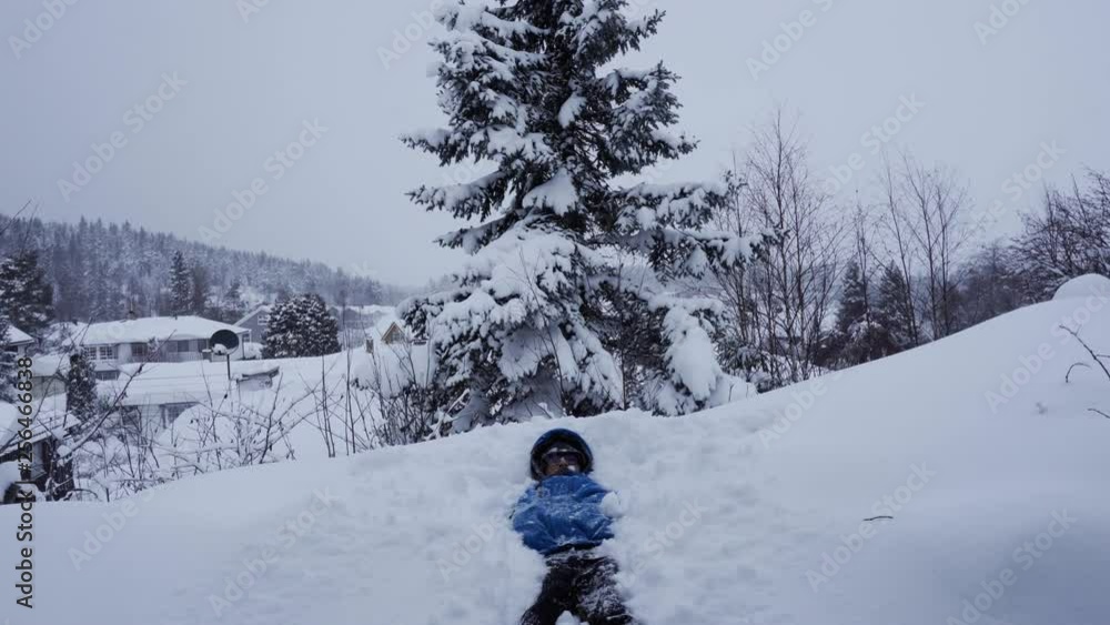Young man is falling in the big deep pile of snow for fun in Norway. Young man is falling in the big deep pile of snow for fun in Norway.