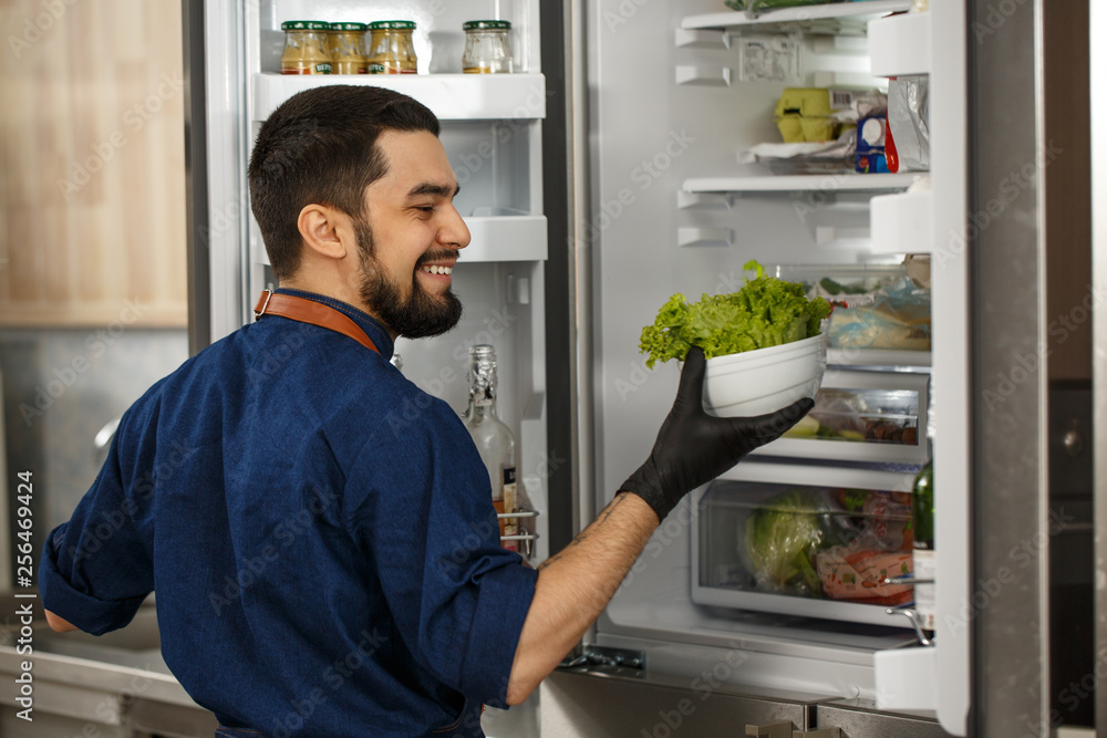 Handsome professional chef cooking at the kitchen Handsome professional chef cooking at the kitchen