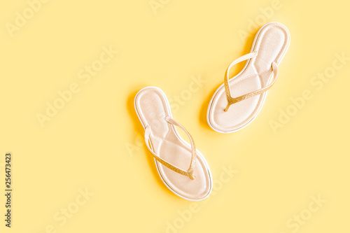 Women's summer sandal isolated on yellow background. Flat lay, top view minimal concept.