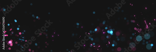 blurred magenta and cyan sparks from neon lights in front of black backgound photo