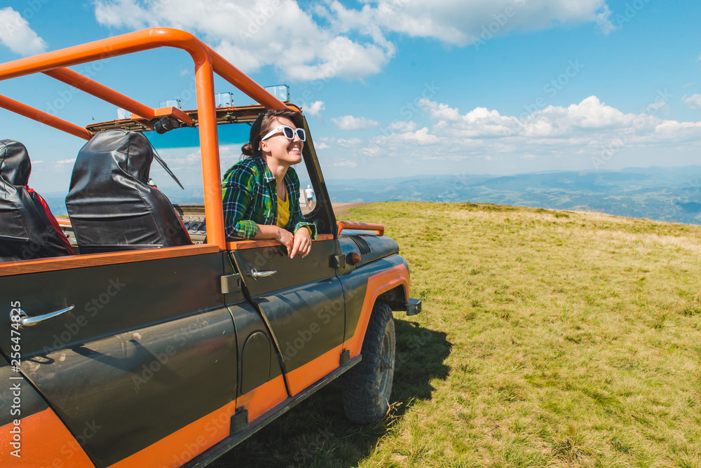 Obraz premium woman in off road cur at the top of the mountain. beautiful view on background. copy space