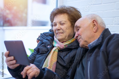older couple or grandparents with a digital tablet or laptop