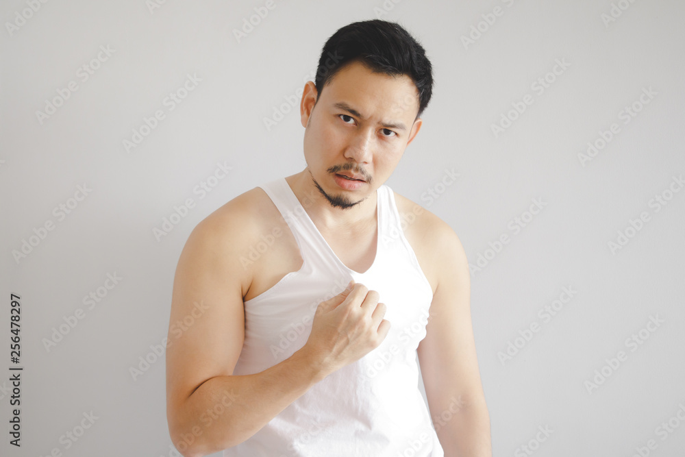 Man in white tank top with hot weather expression. Concept of hot weather of the sun in Asia. Man in white tank top with hot weather expression. Concept of hot weather of the sun in Asia.