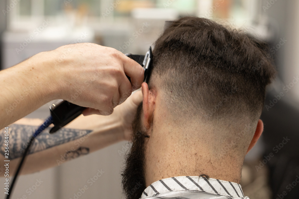 Fototapeta premium Young Man in Barbershop Hair Care Service Concept 