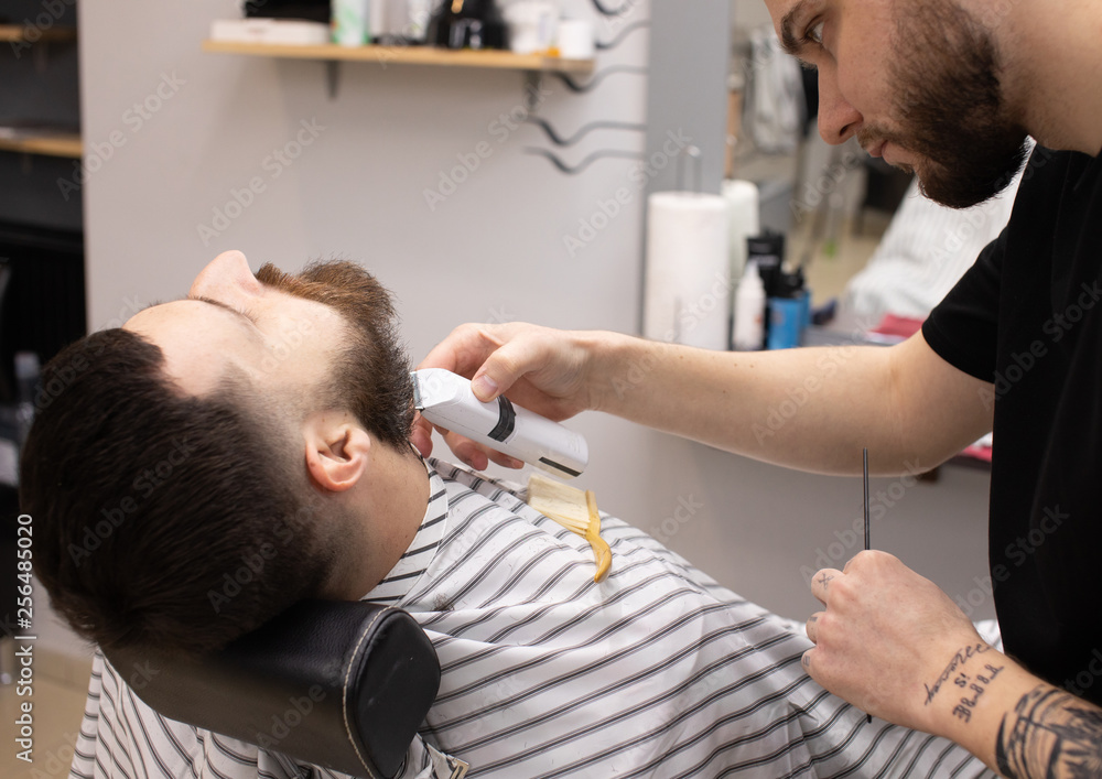 Client during beard shaving in barber shop Client during beard shaving in barber shop