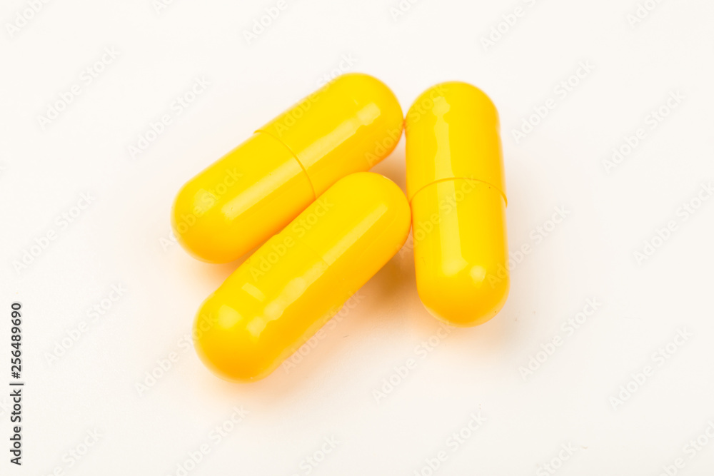 yellow capsules close up on white background