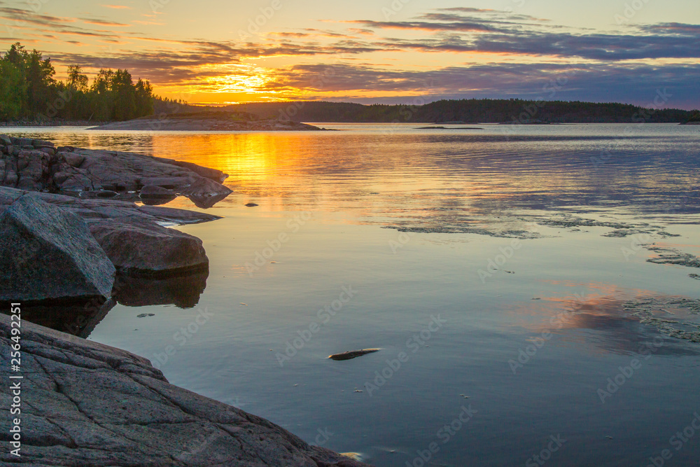 Rocky coast of the island. Sunrise in the wild. Sunrise Sun over the lake. Stones in the water. Islands in Lake Ladoga. Karelia. The nature of Russia. Ladoga lake.