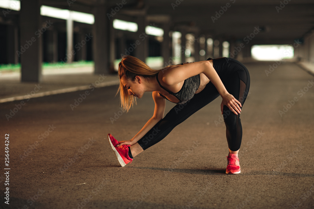 Young woman stretching before running Young woman stretching before running