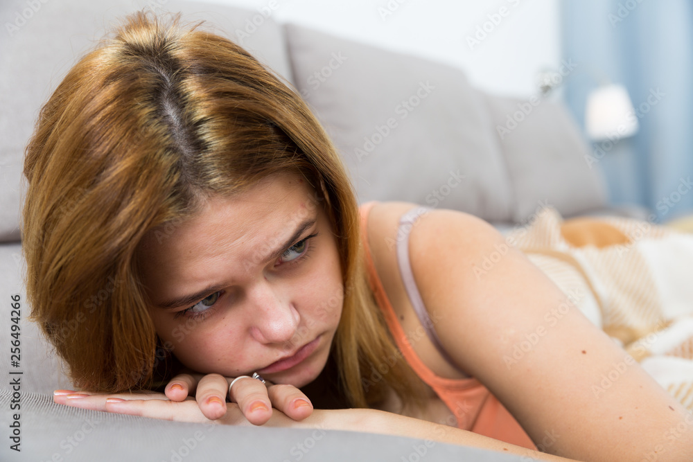Obraz premium sad female on cozy sofa at home