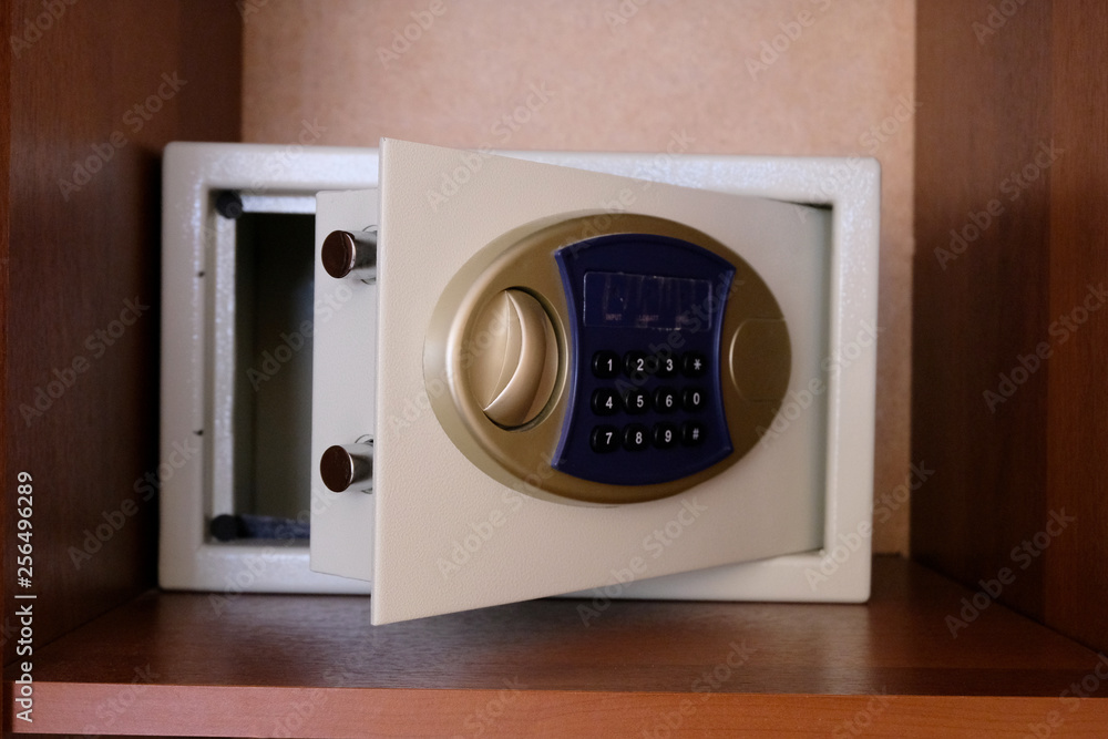 Open safe located on the shelf in the closet. Secure vault code digital lock. The concept of safety of money and valuables. Service at the hotel. Open safe located on the shelf in the closet. Secure vault code digital lock. The concept of safety of money and valuables. Service at the hotel.