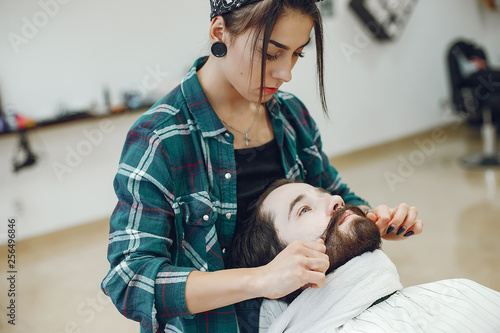 Man with a beard. Hairdresser with a client. Woman with a towel