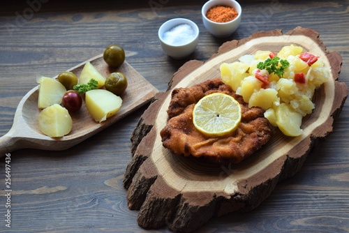 Weiner schnitzel with potato salad on a wooden background
