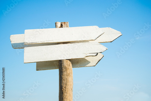 empty white wooden sign board against blue sky