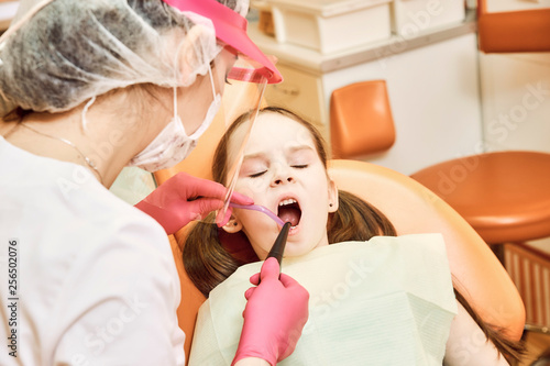 Pediatric dentistry. Dentist treats teeth of little girl