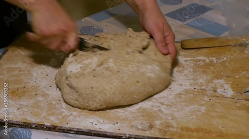 Female hands cut bread dough into pieces close up