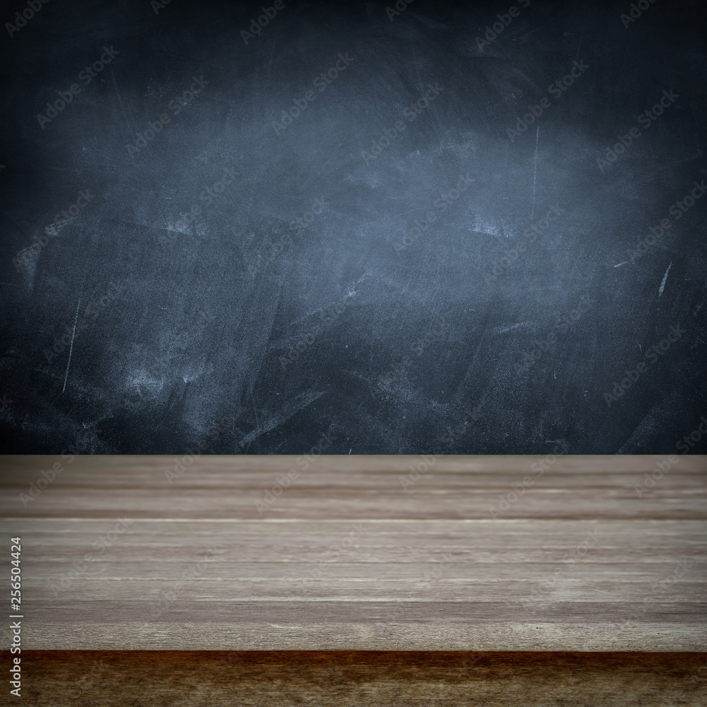Empty wooden table and chalkboard wall