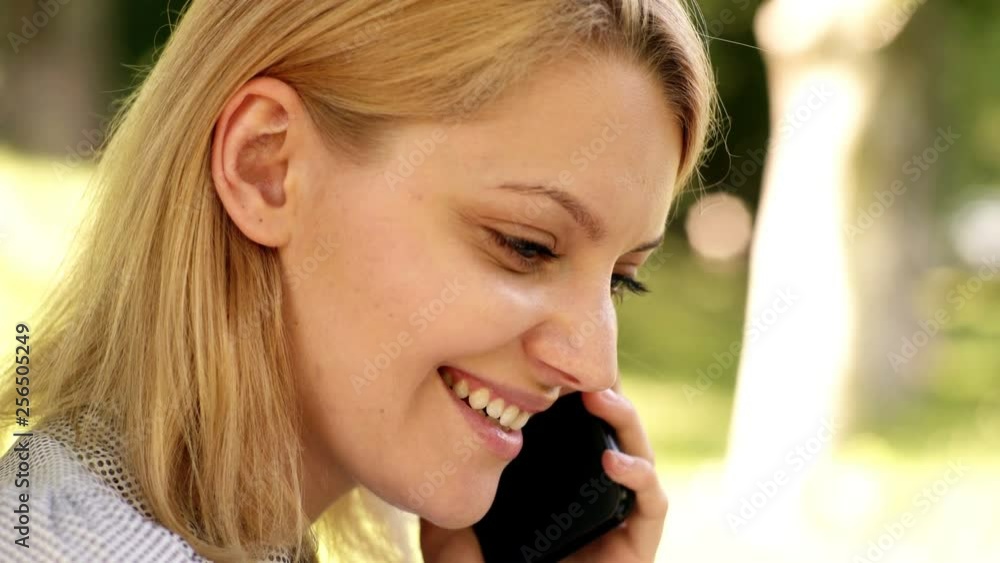 Natural environment office. Work outdoors benefits. Education technology and internet concept. Online dream job. Close-up of a girl which speaks by telephone in the park. Background summer green park. Natural environment office. Work outdoors benefits. Education technology and internet concept. Online dream job. Close-up of a girl which speaks by telephone in the park. Background summer green park.