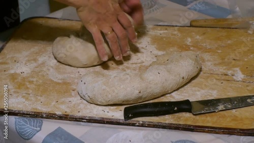 Women hands knead rye dough with cumin 