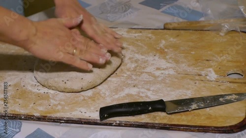 Women hands knead rye dough with cumin close up