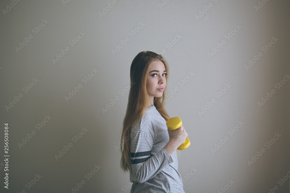 Slim blonde girl with dumbbells in hands,exercises Slim blonde girl with dumbbells in hands,exercises