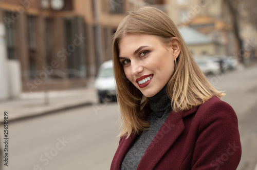 Closeup portrait of young attractive woman outdoors with copy space. Beautiful blond girl model. Cheerful lady on neutral background spring, fall, autumn