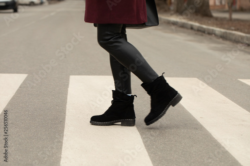 close up of woman legs walking on crosswalk