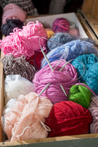 Wool in coils and balls for knitting, knitting needles.  in a large wooden chest