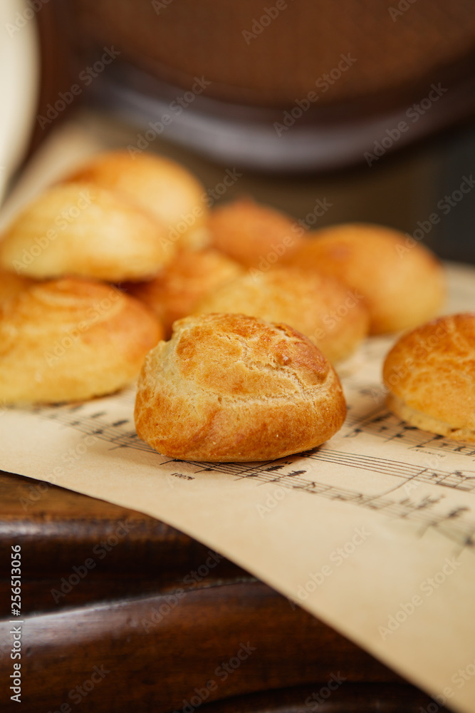 Homemade profiteroles on the music sheet with notes. Profiteroles (choux à la crème) - French choux pastry balls filled with custard or cottage cheese