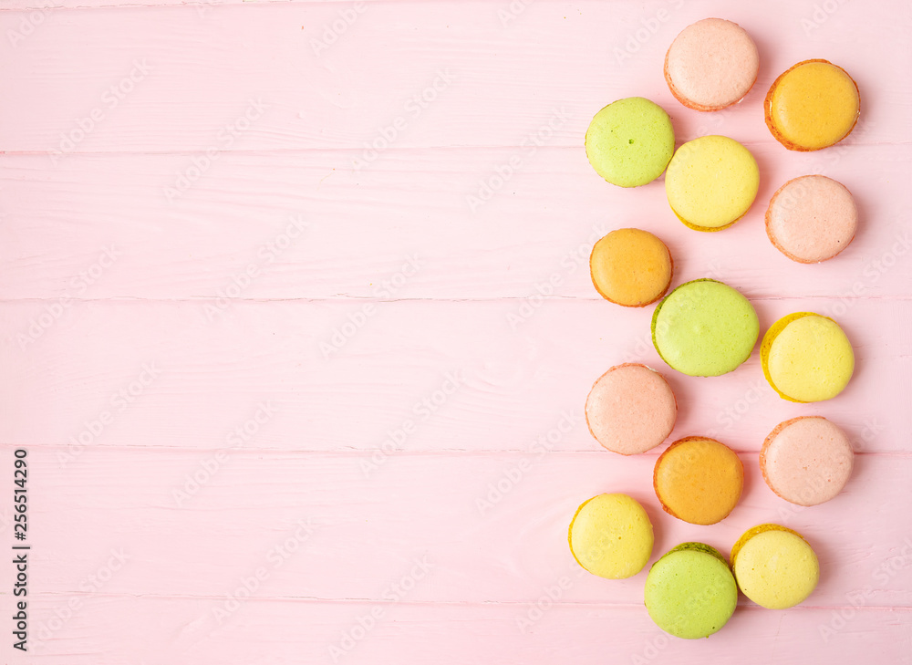 Multicolored macaroons on pink background.