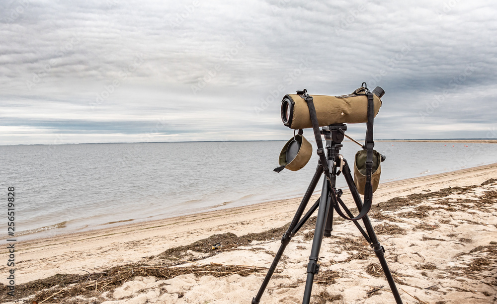 Close up of the telescope on the beach, ready to watch birds.