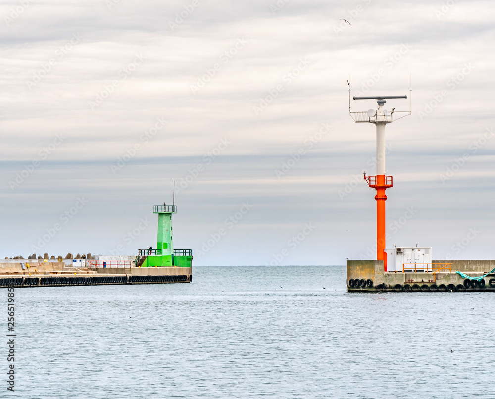 Radar tower and lighthouse at the entrance to the sea port.