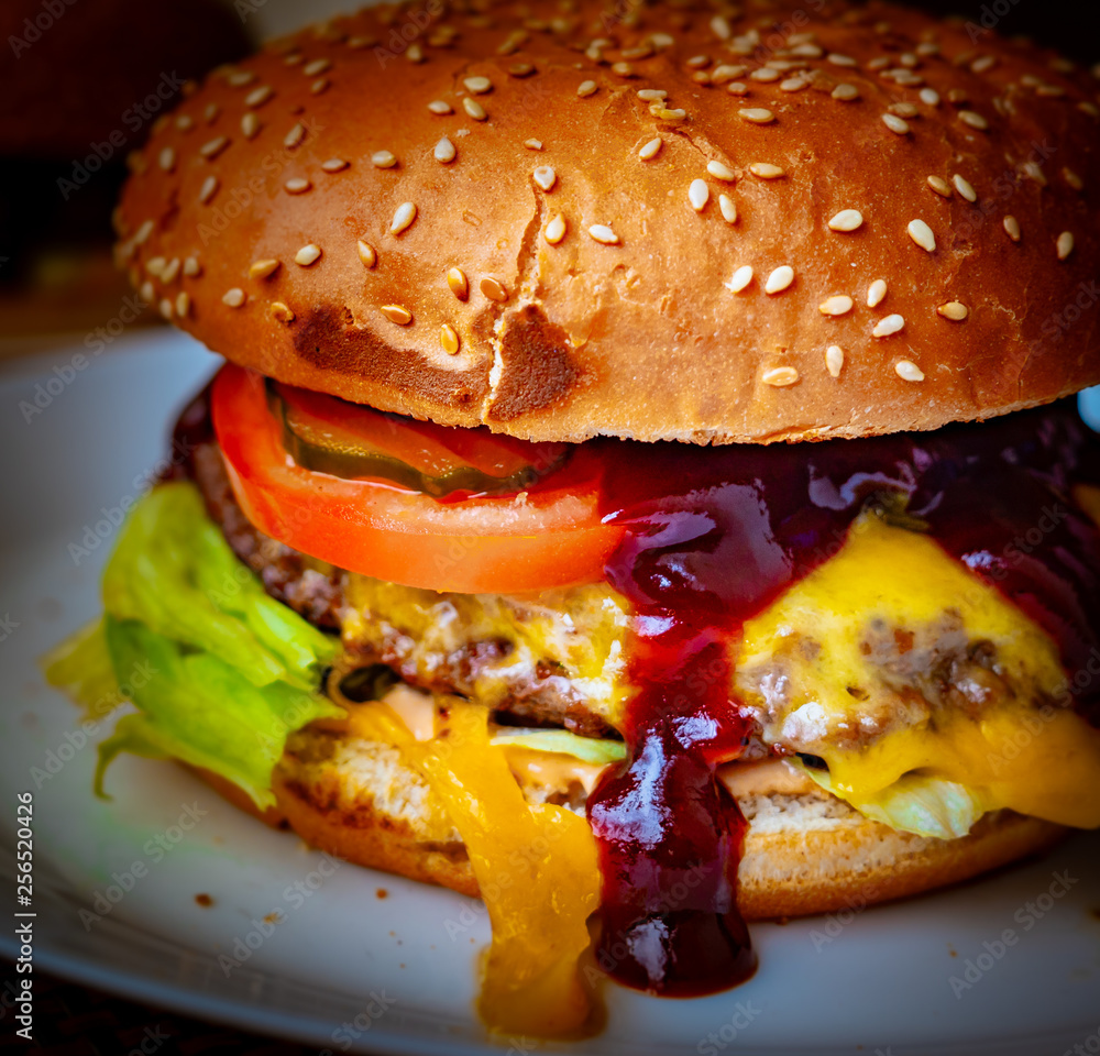 Close-up of delicious fresh home made burger with lettuce, cheese, onion and tomato