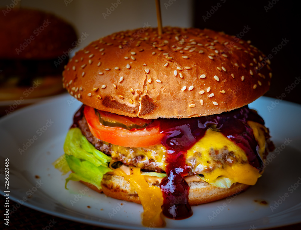Close-up of delicious fresh home made burger with lettuce, cheese, onion and tomato