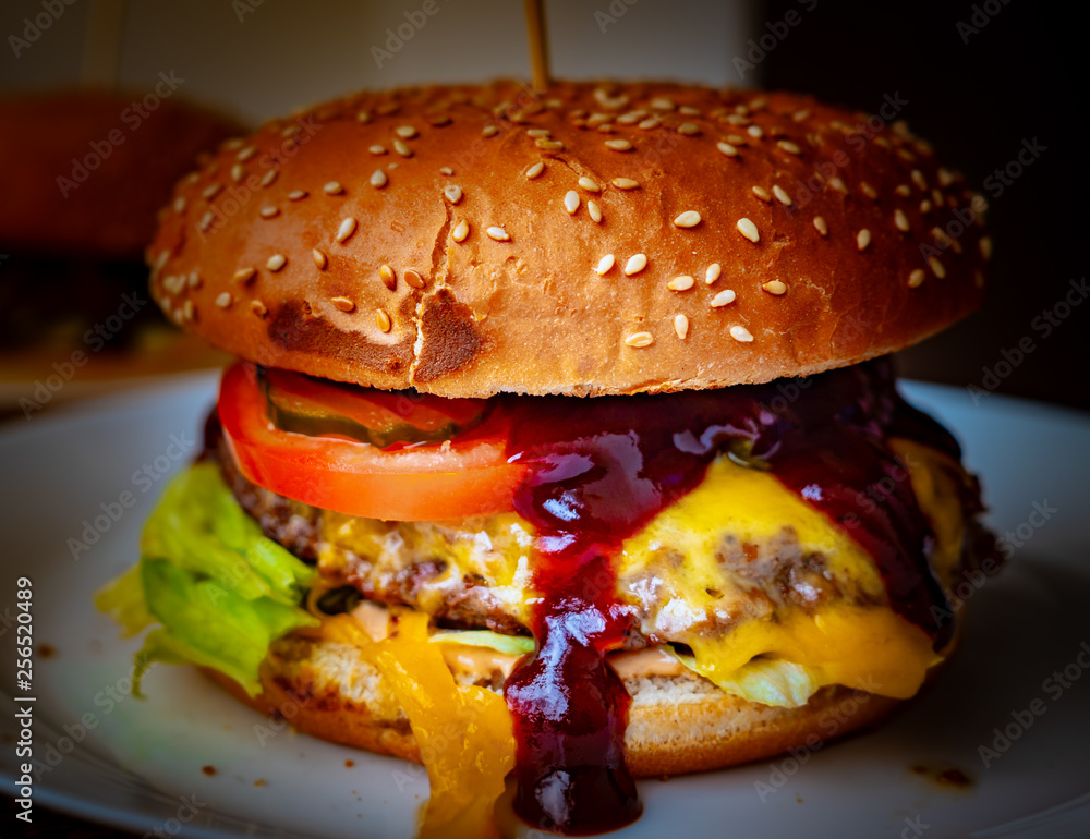 Close-up of delicious fresh home made burger with lettuce, cheese, onion and tomato