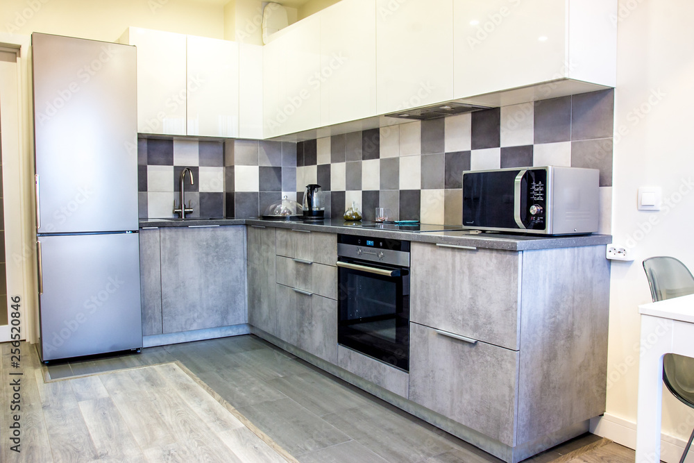 Fototapeta premium Modern home interior kitchen decor elements with gray cement set and segments of luxury furnishings empty apartment with appliances and fridge