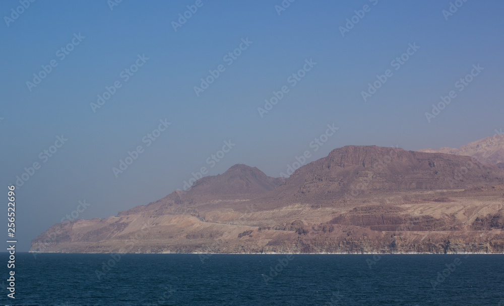 dead sea panorama travel photography scenery landscape view of sand shoreline and bare mountain ridge along waterfront 