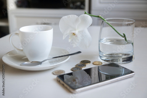 Flat lay financial planning, hand doing calculation with mobile phone and objects on yellow table top.