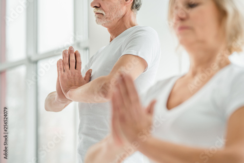 Sporty senior couple doing breathing exercise in yoga class.Health concept.