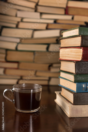  cup and many books on a wooden table