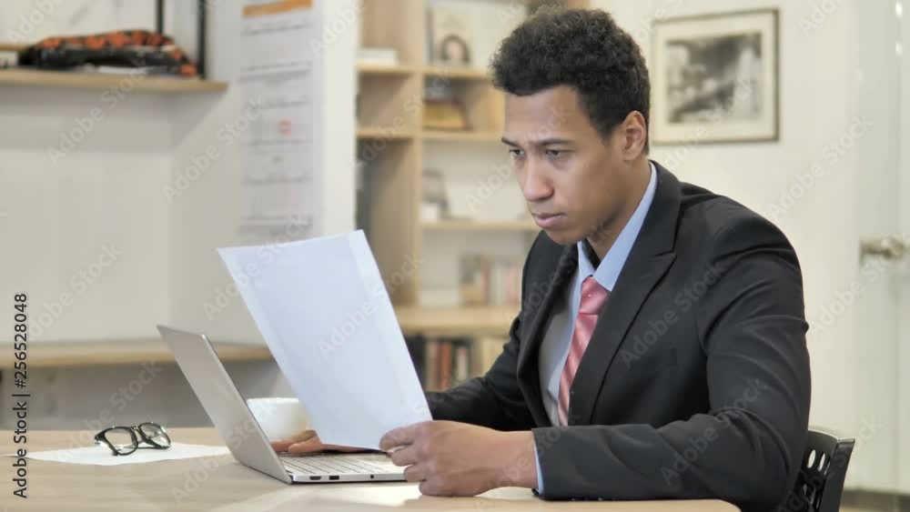 African Businessman Reading New Contract at Work African Businessman Reading New Contract at Work