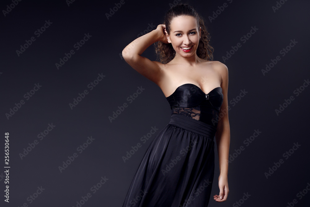 Portrait of fashionable elegant girl in black evening dress on dark background. Evening look. Concept formal prom party Portrait of fashionable elegant girl in black evening dress on dark background. Evening look. Concept formal prom party