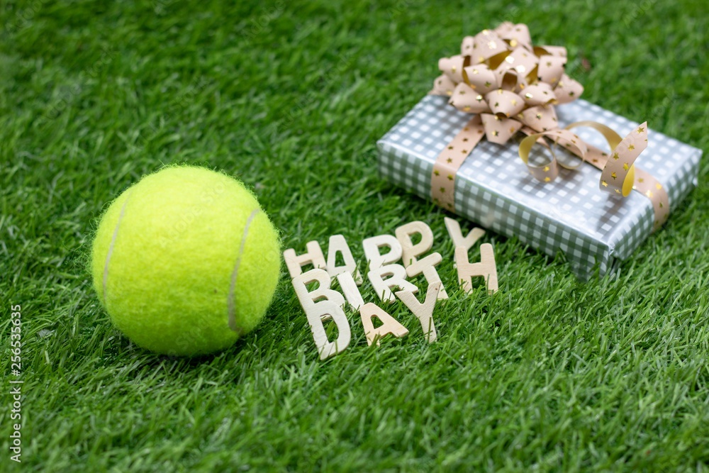 Naklejka premium Happy Birthday to Tennis Player with gifts on green grass