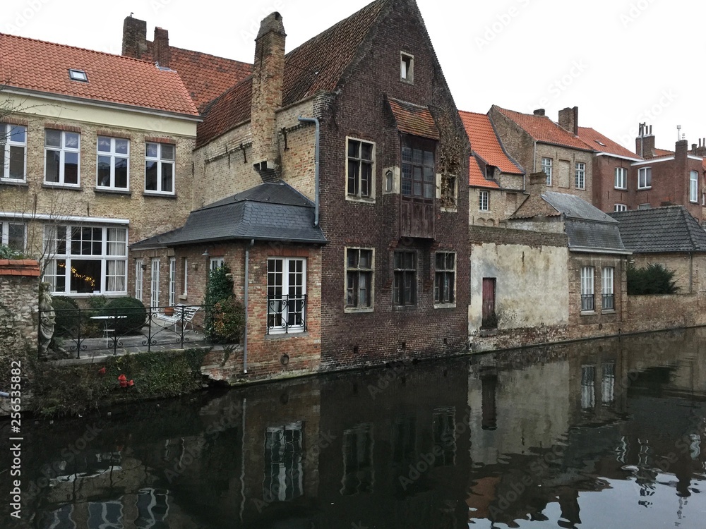 View of residential houses on the Gouden Hand canal on a cold winter day in Bruges, West Flanders, Belgium.