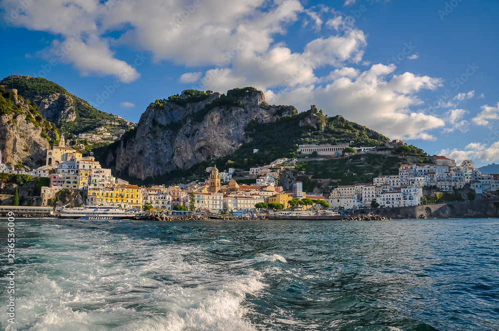 Panorama of the center of Amalfi from the sea, with a ferry departing from the pier