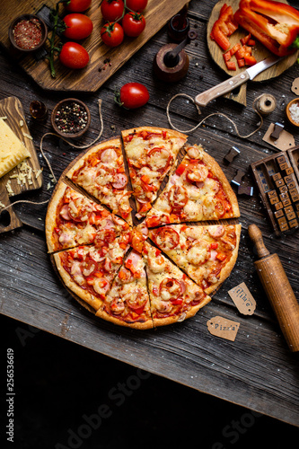 Overhead shot of yummy pizza on rustic dark table