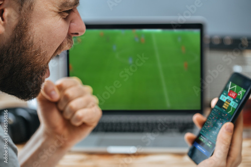 Man celebrating victory after making bets at bookmaker website photo