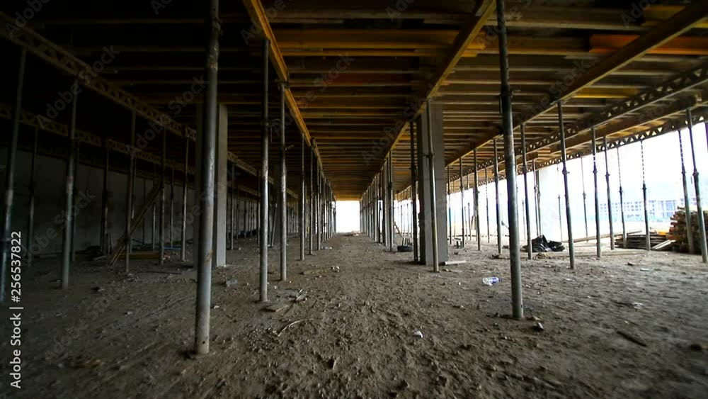 Movement of the camera between the building supports that support concrete structures. Unfinished floor on the construction site Movement of the camera between the building supports that support concrete structures. Unfinished floor on the construction site