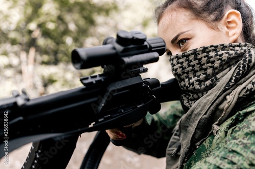 Girl soldier with a sniper rifle in his hands. Military concept of women's army