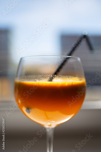 Glass of orange juice over window background.