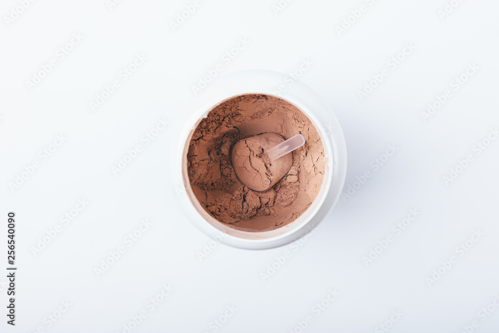 Fototapeta premium Open container of chocolate protein powder with scoop